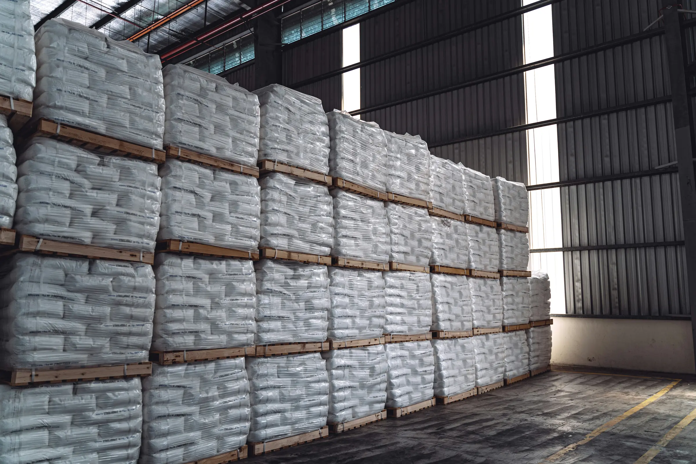 Pallets of bagged goods stacked inside a warehouse